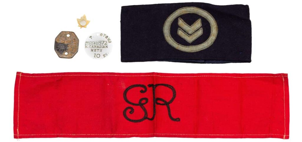Items from the Toshimitsu Otomo collection. Top right: armband, circa 1916. NNM 2016.23.1.1.1. Bottom: armband worn for the King and Queen's visit to Vancouver in 1939, when First World War veterans acted as guards around the city. NNM 2016.23.3.1.1. Top: lapel pin, circa 1939. NNM 2016.23.2.1.2. Private Toshimitsu Otomo's military identification discs, 1916. NNM 2016.23.1.2.1-2.